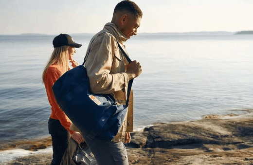 Man & women holding a travel duffel bag 
