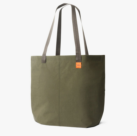 Green tote bag with brown handles on a white background